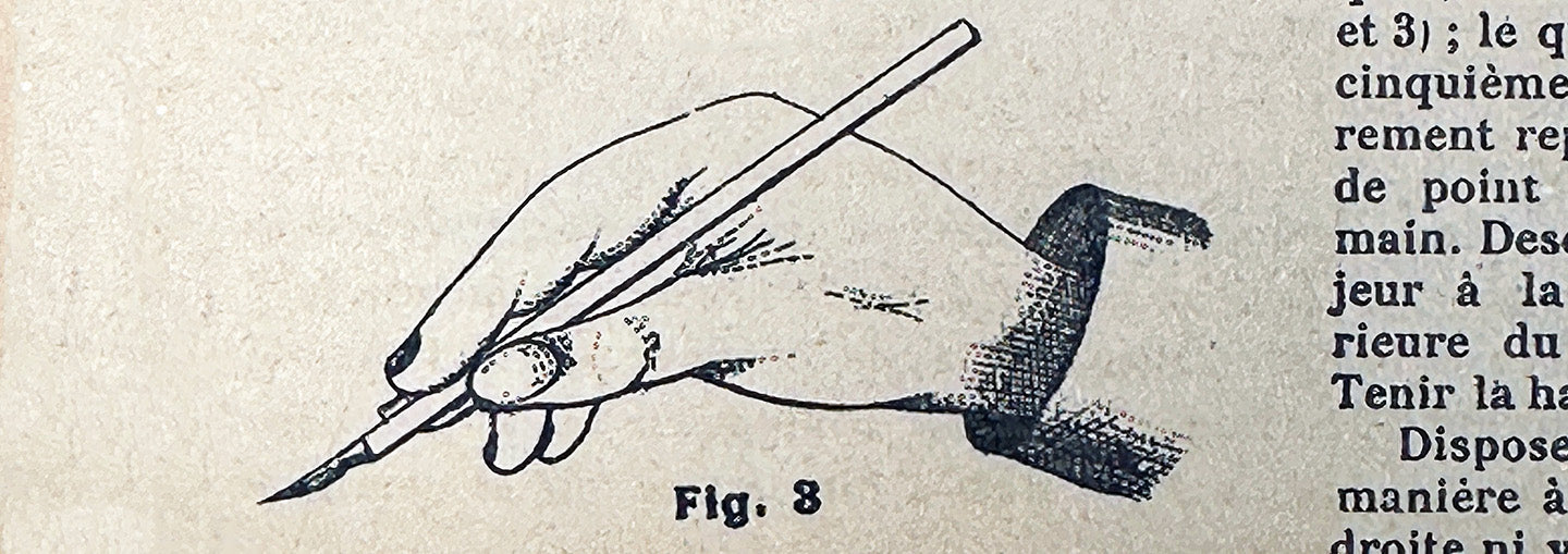 Vintage French illustration showing the correct way to hold a calligraphy pen, from an early 20th-century penmanship manual.